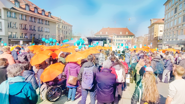 Menschenmenge an der Demonstration für die Umsetzung der UNO-BRK, viele mit orangen Procap-Schirmen