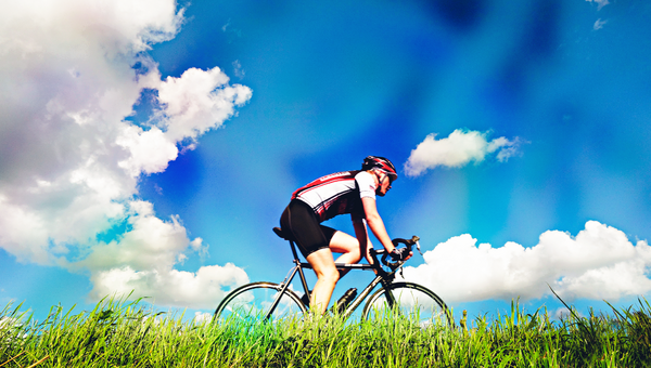 Ein Velorennfahrer vor blauem Himmel